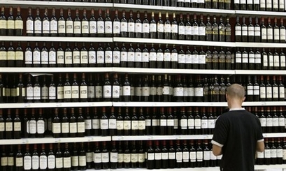 A shopper chooses a bottle of wine. French wine lovers are rushing ...