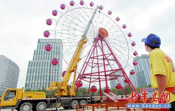 啤酒城内,工作人员正在进行摩天轮装饰施工。